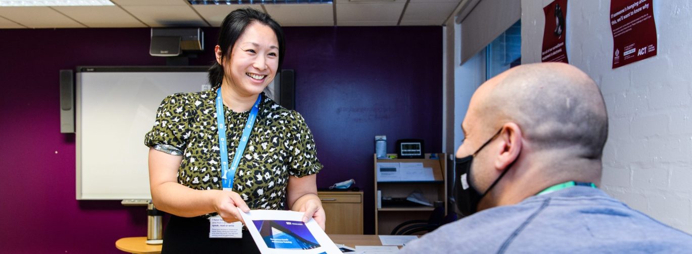 Woman handing man document