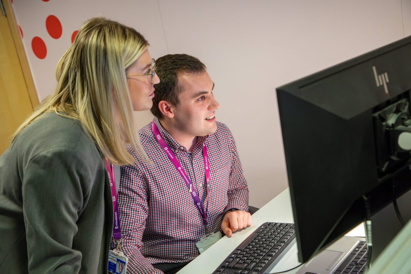 A male and Female colleague staring at a screen in work