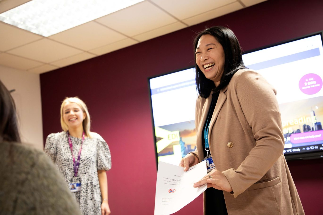 Two female employees smiling as they deliver training